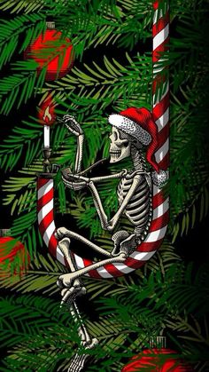 a skeleton sitting on top of a christmas tree holding a lit candle in its hand