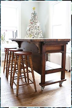 an old kitchen island with stools and a christmas tree on the top in front of it