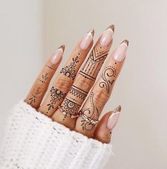 a woman's hand with hendix on it, and some finger tattoos