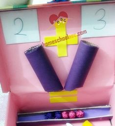 an open pink box with purple and yellow items in it that are on top of each other