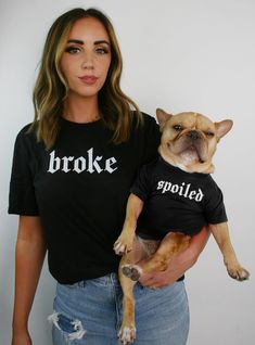 a woman holding a dog wearing a shirt that says broke + spoiled matching tshirt