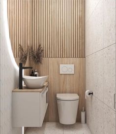 a white toilet sitting next to a sink in a bathroom under a wooden paneled wall