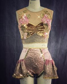 a mannequin is dressed up in gold and pink clothing with sequins