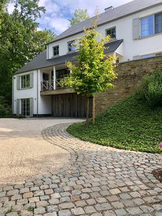 a large white house sitting on top of a lush green hillside