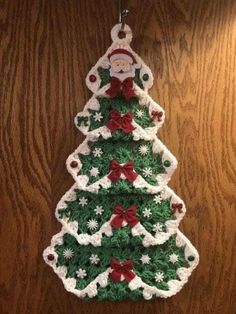 a crocheted christmas tree ornament hanging on a wall