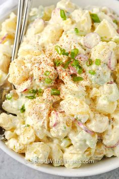 a white bowl filled with potato salad on top of a table