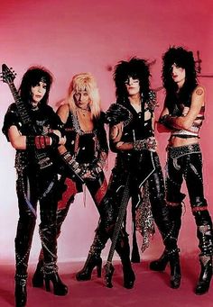 three women dressed in punk clothing posing for a photo with their guitars and guitar strings