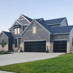 a large gray house with two garages on each side