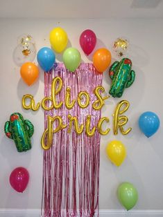 balloons and streamers are on the wall next to a sign that says, alcos prick