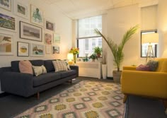 a living room filled with furniture and pictures on the wall