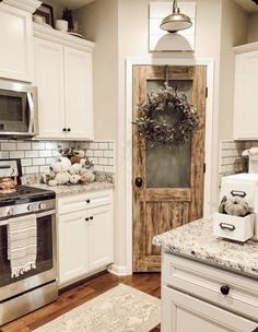 a kitchen with white cabinets and a wreath on the door