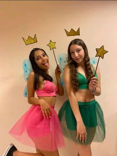 two young women dressed in fairy costumes posing for the camera with wands and stars