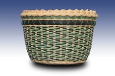 a green and brown woven basket on a white background