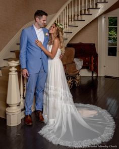 a bride and groom standing in front of the stairs