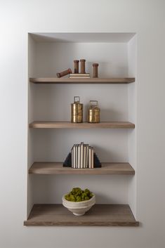 a bowl of pickles and some books on shelves