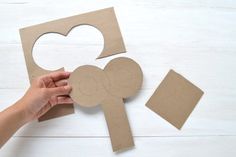 someone is cutting out the shape of a paper heart and another piece of cardboard that has been cut into it