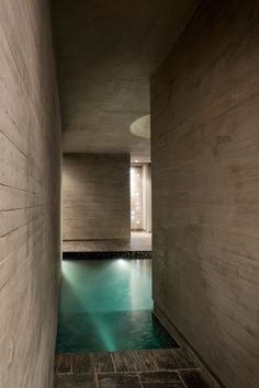 an indoor swimming pool in the middle of a room with tile flooring and walls