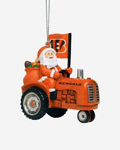 an ornament shaped like a tractor with a santa clause on it