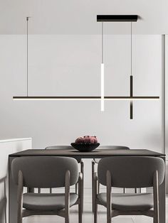 a dining room table with chairs and a bowl of fruit on it, hanging from the ceiling