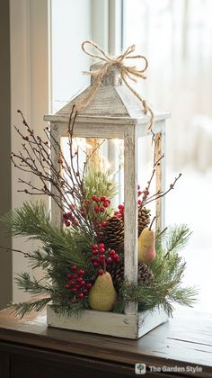 a lantern filled with pine cones and berries