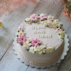 there is a cake with flowers on it and the words jelamat uang tahun