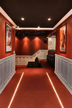 an empty theater room with red carpet and white walls