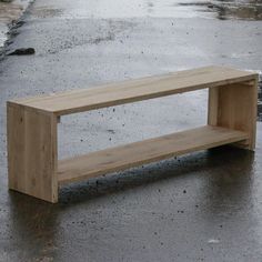 a wooden bench sitting on top of a wet parking lot