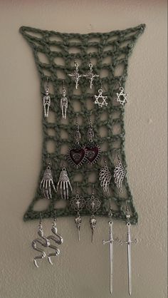 a crocheted wall hanging with lots of earrings on it