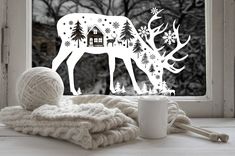 a white deer is standing in front of a window with snowflakes on it