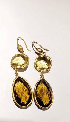 These vintage earrings are quite stunning and just what you need for special occasions. They feature faceted round and teardrop shaped smoky and yellow quartz in gold settings that catch the light just perfectly. They dangle from gold-toned ear wires. From the top of the wire to the bottom of the pearl, they measure 3 inches. These earrings are in very good vintage condition. Thanks for visiting my vintage jewelry store! Back to my shop here: https://www.etsy.com/shop/RemembrancesofYours Elegant Gold Teardrop Earrings With Gemstone, Gold Faceted Citrine Earrings, Gold Citrine Faceted Earrings, Elegant Gold Citrine Earrings, Gold Drop Earrings With Faceted Details, Gold Teardrop Gemstone Earrings For Wedding, Gold Faceted Drop Earrings, Gold Faceted Earrings For Anniversary, Elegant Yellow Faceted Earrings