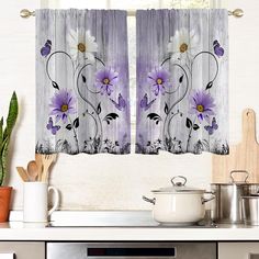 the kitchen curtains are decorated with purple and white flowers on wood planks, along with pots and utensils