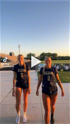 two girls are walking down the sidewalk together