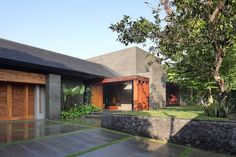 the house is made out of concrete and has two garages on each side, with an open door leading to another room