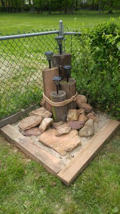 an outdoor fountain made out of wood and rocks