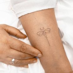 a woman's arm with a small tattoo on it