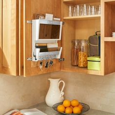 a microwave oven sitting inside of a kitchen next to oranges on a counter top