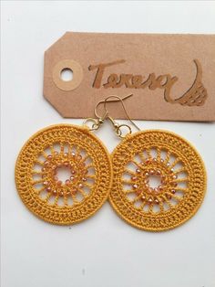 the earrings are made with crochet and beaded in gold tone, along with a tag that says town