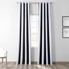 black and white striped curtains hanging on a wall next to a chair in front of a window