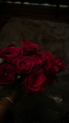 a bouquet of red roses sitting on top of a table