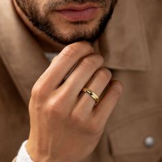 a man wearing a gold ring and jacket