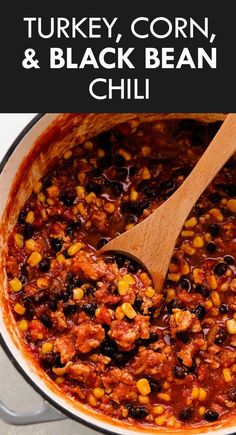 turkey, corn and black bean chili in a pot with a wooden spoon on the side