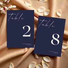 two cards with the numbers twenty and thirty on them, sitting next to some flowers