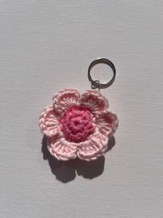 a crocheted flower keychain is shown on a white surface with a pink center