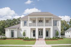 a large white house sitting on top of a lush green field