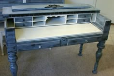 an old desk has been painted blue and white with some drawers on the bottom shelf