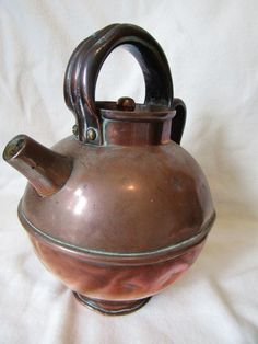 an old tea kettle sitting on top of a white sheet