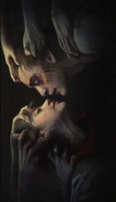 two people in the dark with their hands on each other's face and one person holding an object