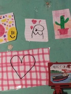 the wall is decorated with pictures and drawings on it, including a heart shaped paper