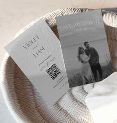 two save the dates cards sitting on top of a plate