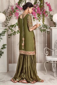 Opt for this stunning olive hued ensemble featuring multi colored floral embroidery further enhanced with dabka, sequins and beads, paired with jacquard cotton net gharara and beautifully composed dupatta with heavy sequin and gota embellishments. Hand crafted tassels completes the look. Shirt Fabric: Cotton NetShirt Length: 34” (customisable, mention in order notes)Sleeves: 11” (customisable, mention in order notes)Gharara Fabric: Jacquard Cotton NetDupatta Fabric: NetShirt , Gharara & Dupa Pista Green Palazzo Set With Mirror Work, Designer Sharara With Intricate Embroidery And Straight Kurta, Pista Green Lehenga With Resham Embroidery And Straight Kurta, Unstitched Pista Green Sharara With Dabka Work, Festive Dola Silk Sharara With Intricate Embroidery, Festive Chinon Sharara With Intricate Embroidery, Festive Pista Green Palazzo Set With Intricate Embroidery, Festive Pista Green Embroidered Palazzo Set, Designer Sharara With Dabka Work And Straight Kurta